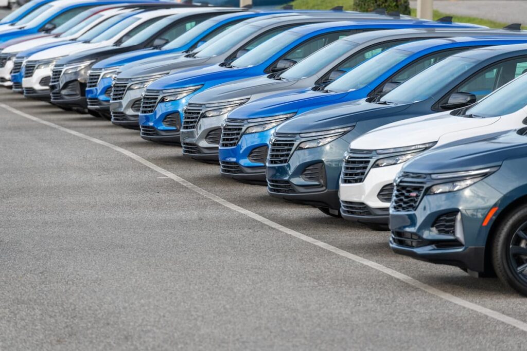 Eine Reihe von blauen und weißen Fahrzeugen, die in einer Reihe auf einem Parkplatz stehen